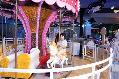 طفل سعودي يركب لعبة الملاهي الدوارة في مركز ترفيهي