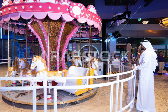 Emirati Man with Family at Indoor Carousel Theme Park