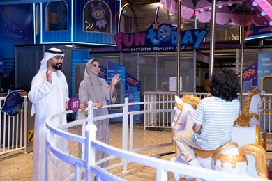 Emirati Family at Indoor Amusement Park Carousel