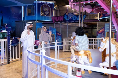 عائلة إماراتية في مدينة ملاهي مغلقة يلوحون لطفلهم