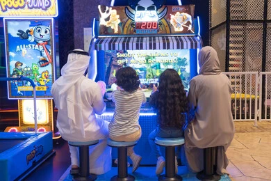عائلة إماراتية تلعب ألعاب الفيديو في مركز ترفيهي