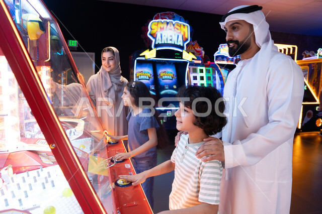 Emirati Family Playing Arcade Games in Entertainment Center