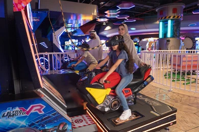 Emirati Family Playing VR Motorcycle Game in Arcade