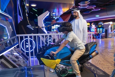 رجل إماراتي وطفل في مركز ألعاب واقع افتراضي