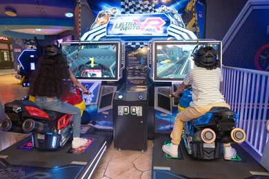 Children Playing Virtual Reality Motorcycle Racing Game