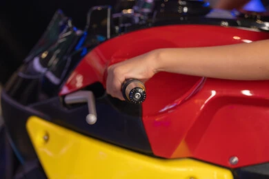 لقطة قريبة ليد على مقبض دراجة نارية حمراء وصفراء