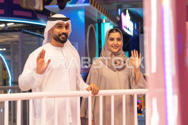 رجل وامرأة من الإمارات يلوحان في مركز ترفيهي