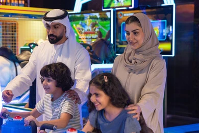 Emirati Family Playing Arcade Games Indoor Center