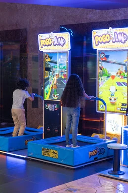 أطفال يلعبون ألعاب الترامبولين التفاعلية في صالة الألعاب