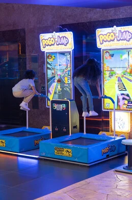 أطفال يلعبون لعبة فيديو تفاعلية في مركز ترفيهي