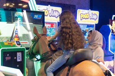 فتاة سعودية على جهاز محاكاة سباق الخيل