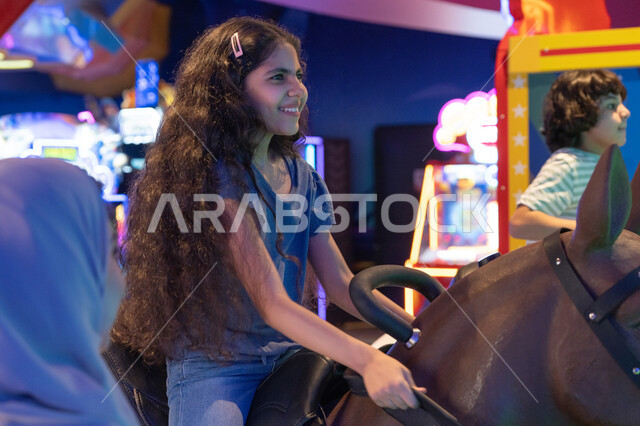 Saudi Girl Playing Mechanical Horse Game in Arcade