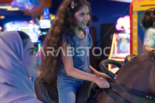 Saudi Girl Playing Mechanical Horse in Arcade Center