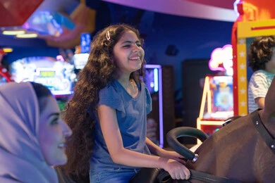 طفلة سعودية تبتسم في ملاهي ترفيهية داخلية