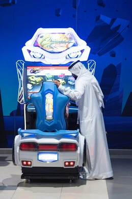 رجل سعودي عند جهاز محاكاة سباق سيارات إلكتروني