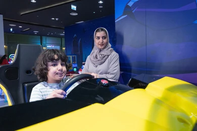 أم سعودية وابنها في جهاز محاكاة سباق السيارات