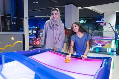 Saudi Mother and Daughter Playing Air Hockey Indoor Saudi Mother and Daughter Playing Air Hockey Indoor