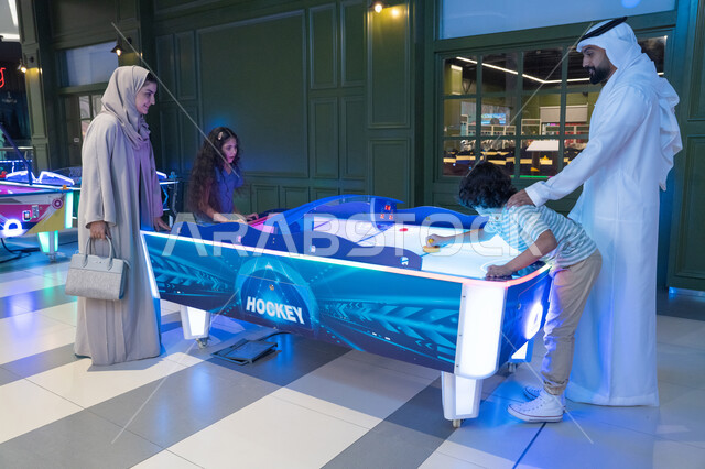 عائلة إماراتية تلعب الهوكي الهوائي في مركز ألعاب