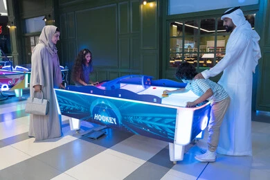 عائلة إماراتية تلعب الهوكي الهوائي في مركز ألعاب