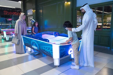 عائلة إماراتية تلعب الهوكي الهوائي في مركز ترفيهي