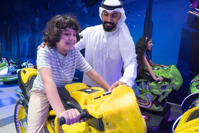 أب إماراتي وابنه يلعبان لعبة دراجات نارية في أركيد