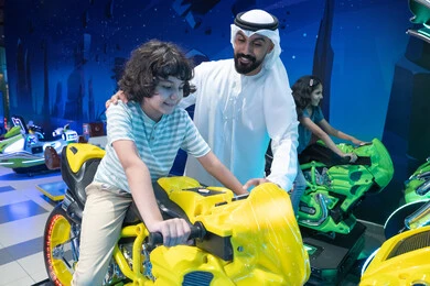 أب إماراتي وابنه يلعبان بمحاكي الدراجات النارية