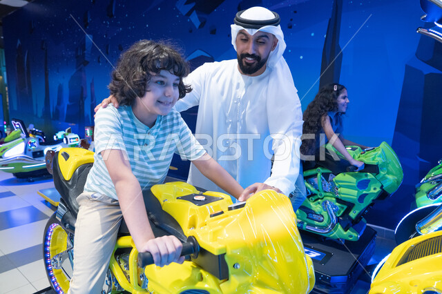 أب وابنه إماراتيان يلعبان في مركز ألعاب ترفيهي