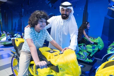 أب وابنه إماراتيان يلعبان في مركز ألعاب ترفيهي