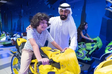 أب إماراتي وابنه يلعبان ألعاب الفيديو في الملاهي