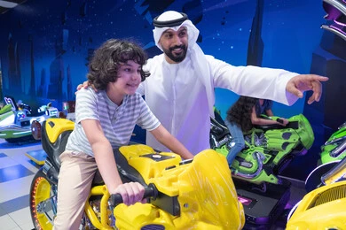 أب وابنه بملابس إماراتية في مركز ألعاب ترفيهي
