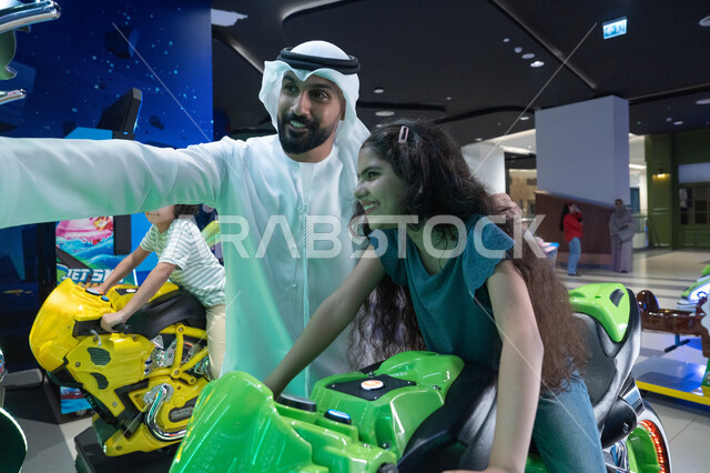 Emirati Father and Daughter at Indoor Arcade Center
