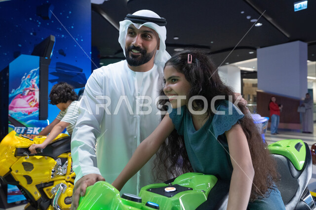 Emirati Father and Daughter at Indoor Gaming Center