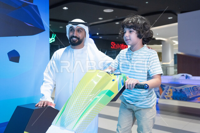 Emirati Man and Boy Using Simulation Game Indoors