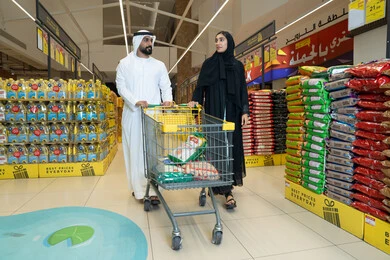 زوجان عربيان يتسوقان معاً في ممر السوبر ماركت بالخليج