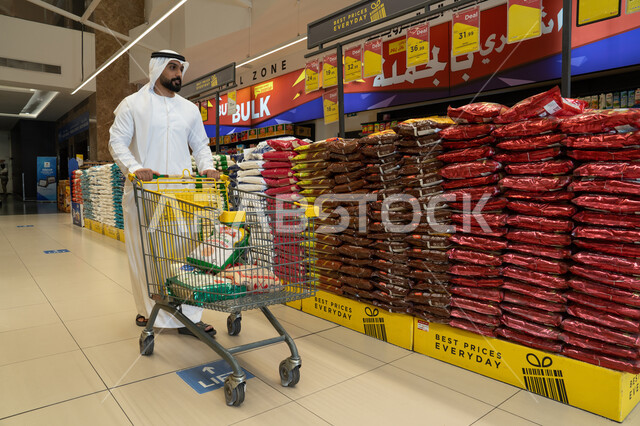 رجل إماراتي يتسوق في هايبر ماركت مع عربة