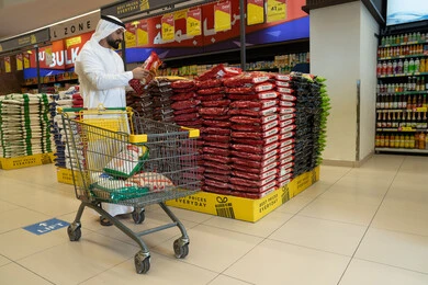 رجل إماراتي يتسوق في السوبر ماركت مع عربة رجل إماراتي يتسوق في السوبر ماركت مع عربة