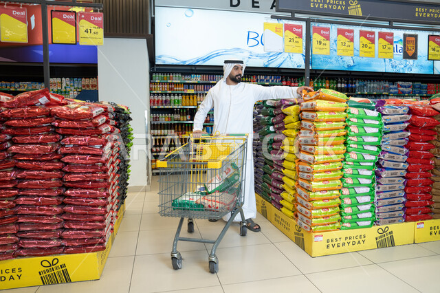 Emirati Man Shopping for Rice Bags in Supermarket Aisle