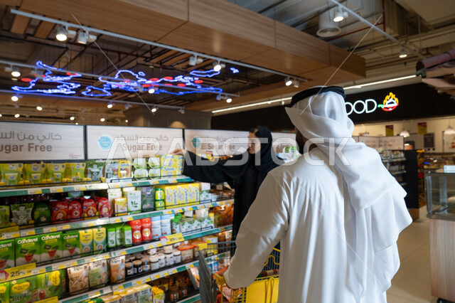زوجان إماراتيان يتسوقان في قسم السكر في السوبر ماركت