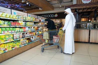 عائلة إماراتية تتسوق في ممر السوبر ماركت
