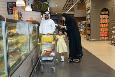 عائلة إماراتية تتسوق في قسم المخبوزات بالسوبر ماركت