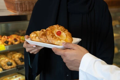 Emirati Man Buying Fruit Pastries in Bakery Close-up