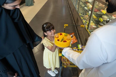 عائلة إماراتية تشتري كعكة فواكه داخل متجر سوبر ماركت