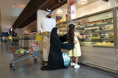 عائلة إماراتية تتسوق في قسم المخبوزات بالسوبر ماركت