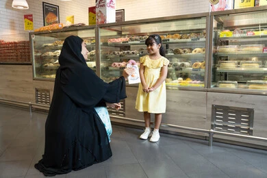 أم إماراتية وابنتها في محل حلويات
