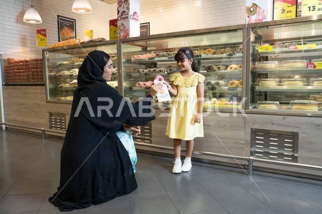 Emirati Mother and Daughter in Traditional Dress at Bakery