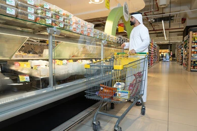 رجل إماراتي بالكندورة يتسوق في السوبر ماركت