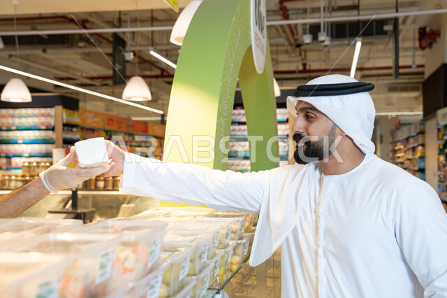 رجل إماراتي يرتدي الكندورة يتسوق في السوبر ماركت