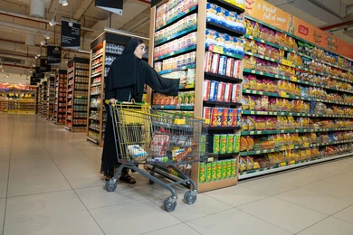 Emirati Woman Shopping in Supermarket Aisle with Cart