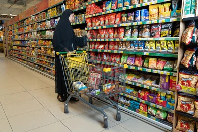 Emirati Woman Grocery Shopping in Supermarket Aisle