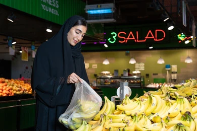 امرأة إماراتية تتسوق الموز الطازج في السوبر ماركت امرأة إماراتية تتسوق الموز الطازج في السوبر ماركت
